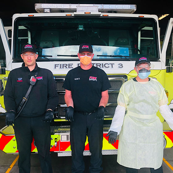 Fire District 3. Three people in front of Engine.